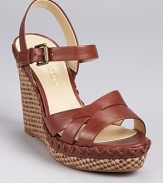 A lace-up inspired detail around the midsole adds a unique touch to Enzo Angiolini's Greyti sandal, boasting a textured wedge heel as a final finishing touch.