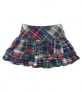 A bright patchwork plaid cotton skirt features tiers of ruffles for a fun and girlie look.