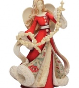 Spread joy throughout your home with this beautifully detailed angel figurine. With a floral design upon her robe, a sweet garland of hearts and snowflakes and crystal accents, she's sure to light up your holiday season.