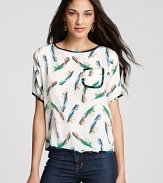 Floating feathers make their way down Tucker's short sleeve top, crafted in luxe silk with black contrast trim.