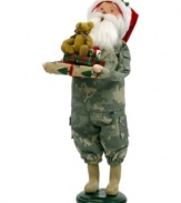 Singing their praises, Santa Claus honors military families in a camouflage suit and iconic red hat. In his arms are extra-special gifts piled high and topped with an adorable stuffed bear. An all-American figurine, handcrafted by Byers' Choice.