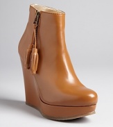 Smooth, sculpted platform wedge booties are enlivened by playful tassel details that give the style just the right amount of kick; by Ted Baker.
