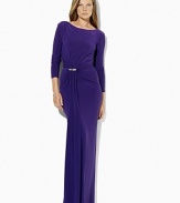 A crystal-encrusted brooch and gathering at the right waist impart sexy sophistication to a sweeping floor-length gown in figure-flattering matte jersey.