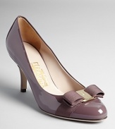 These Salvatore Ferragamo kitten heel pumps are understated yet eye-catching in pale purple patent leather with elegant gold logo bow accents.