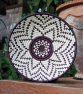 The hand-woven eggplant-purple Ingoma basket design is inspired by the drums that accompany ceremonies for birth, marriage and other important milestones in Rwandan life. Hang it in place of a photo for added interest and dimension.