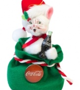 The cat's out of the bag and clutching a different type of holiday bubbly in this cheery Coca-Cola ornament. Crafted with the soft features and unmistakable style of Annalee.