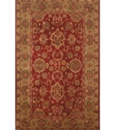 Drawing inspiration from the sandy ruins of ancient Petra and the traditional designs of India, this elegant, hand-tufted rug presents a rich decorative history set against a subtle red backdrop and accented with multiple gold and green tones.