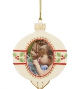 In the shape of a classic Christmas ball, this ornament from Lenox lets you add a personal touch to your tree with a picture frame center. With gold hanging thread.
