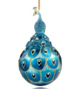 Exquisitely crafted with fine details, this ornament features a pretty peacock sitting upon a ball painted with a peacock feather design. Gold sparkles give it that extra-special shimmer.