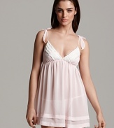 A whimsical babydoll with bow appliqués at straps and beaded trim along the hem.