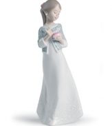 A graceful way of showing you care, this handmade porcelain figurine from Lladro presents a young woman in flowing white with carved detailing upon her dress and sweater wrap.