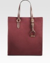 Richly colored canvas combines with supple leather trim for a bold design in a classic shape.Flat leather top handles, 6½ dropRemovable dangling stirrupMagnetic top closureOne inside zip pocketOne inside open pocketOne cellphone pocketCanvas lining13½W X 15½H X 4½DMade in Italy