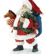 Here Comes Santa Claus! Celebrate the arrival of jolly old Saint Nicholas with this festive figurine featuring Santa and his bag of gifts.