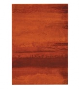 Abstract and dramatic, this handcrafted wool rug features a rich spectrum of shades from burnt orange tones to deep reds. The ethereal coloration pattern is reminiscent of a vivid sky at sunset. Luster-wash finish creates gently-diffused color variation.