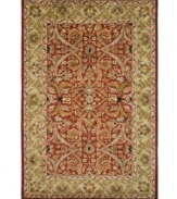 A luxurious arrangement of swirling florals gives this Safavieh area rug a decidedly classical appeal. Tufted in India from pure wool, this rug boasts a background of deep red and a supporting palette of color that creates a beautiful contrast of light and dark. (Clearance)