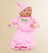 This precious baby doll has blue eyes and a brown curl painted on her forehead. She's dressed in a pink, snuggly soft, sleep sack with a gathered bottom. A picture of a sweet pea on the front has the words sweet pea written beneath it. A matching pink hat with a tassel and a soft plush pacifier in her hand completes this baby's outfit.12 plastic and fabric dollRecommended for ages 0 and upImported