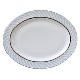 Carefully rendered in a style reminiscent of neoclassic trompe l'oeil-a French term for artwork that depicts optical illusions-a captivating geometric rosette motif traverses this elegant porcelain platter from Bernardaud. Delicate shades of ice blue, mother-of-pearl and gray are enhanced by a fine platinum trim.
