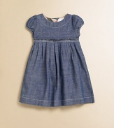 A captivating frock in soft chambray, with a crisply pleated Empire waist and sweet puffed sleeves.Round neckline with topstitchingShort puffed sleevesEmpire waist with stitched pleatsFull button back with check trimCottonMachine washImported Please note: Number of buttons may vary depending on size ordered. 