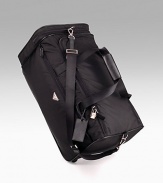 Black nylon with saffiano leather trim rolling duffel with pull-out handle and nylon shoulder strap. Lined with PRADA jacquard fabric 11½H X 21½L X 11¾W Made in Italy 