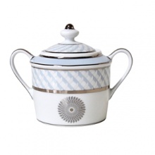 Carefully rendered in a style reminiscent of neoclassic trompe l'oeil-a French term for artwork that depicts optical illusions-a captivating geometric rosette motif traverses this elegant porcelain sugar bowl from Bernardaud. Delicate shades of ice blue, mother-of-pearl and gray are enhanced by fine platinum details.