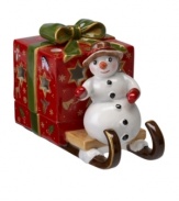 A snowman carries a brilliant surprise on the back of his sleigh in this beautifully crafted candle holder from Villeroy & Boch. Light shines through pierced stars in a present wrapped in charming vintage style.