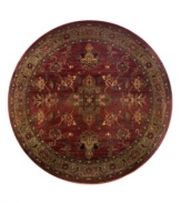 A truly charming interpretation of a traditional carpet, this round rug features a center medallion ringed by palmettes and floral details in sage green, topaz and slate blue against a rich burgundy ground. Striated effects create the weathered look of handmade rugs in a stain-resistant, no-shed manmade fiber.