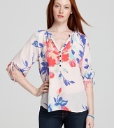 Decorated with a soft floral design and chic ties at the cuffs, this silk Yumi Kim top blooms with femininity.
