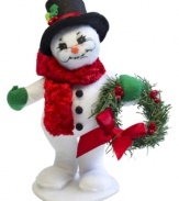 Winter gets a warm welcome with this cozy Christmas snowman. Standing on his own two feet, he greets the season in a velvety red scarf and black top hat. With the soft features and unmistakable style of Annalee dolls.