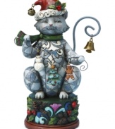 With bells on. Clawing her way to the top of your tree, Jim Shore's Christmas cat carries a few ornaments of her own – a snowman, tree and gingerbread man – and sits up on a pedestal of holly and pine cones.