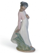 Stopping to smell and pick flowers, a beautiful young girl enjoys a breezy spring day in this delicately glazed figurine from Lladro.