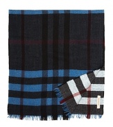 This Burberry plaid scarf is reversible for maximum versatile style. Rich medium blue and black adorn the front, and the reverse features a faded red, blue and black that hints at vintage cool.