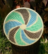 A dreamy swirl pattern is woven in this beautiful fruit bowl, illustrating how wind scatters the seeds of spring throughout Rwanda. Cool aqua and sky blues mingle with earth-brown tones to represent the natural splendor of the season. (Clearance)
