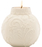 Embossed holly and scroll designs embellish this votive candle holder, perfect for adding a glow to your holiday table. From Lenox.
