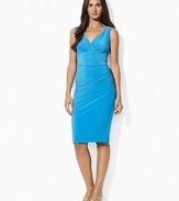 Delicate ruching accents a sleek stretch jersey dress, finished with a flattering crossover neckline and an empire waist for timeless elegance.