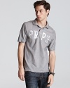 Slim fit polo with faded logo lettering and distressed accents in a slim fit.