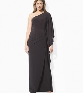 Rendered in luxurious matte jersey, a timeless one-shoulder silhouette is given a decidedly modern update with a dramatic batwing sleeve that softly cascades to the floor.