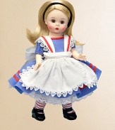 This doll has blue eyes and side-parted, long, ivory blonde hair that's held by a black velvet headband. She's dressed in a blue cotton dress that has short puffy sleeves and red soutache trim. Her white apron, edged with a scalloped lace trim, has red soutache trim on the straps and a heart shaped, appliquéd, lace pocket.