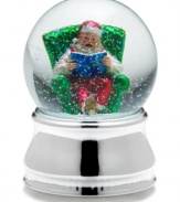 Santa Claus kicks back with a good book, full of beautiful Christmas stories, in this musical snow globe from Towle.