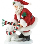 Bundle up! This adorable figurine captures Santa wrapping a polar bear in a festive colored scarf.