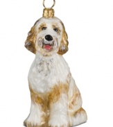 Puppy love at first sight. Just begging for a home, this goldendoodle ornament is irresistible to animal lovers in hand-painted glass by Joy to the World.