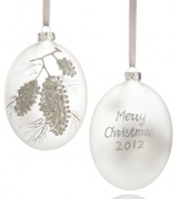 Serene and understated, this frosted glass ornament turns your home into a winter wonderland. Silver pine cones and a message of seasonal cheer glisten in silver glitter. Shown front and back.