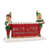 Two smiling elves take the lead in the Brite Lites Christmas parade, a favorite holiday tradition in Department 56's Snow Village.