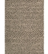 A blizzard of soft spots linger in between imperfect lines, creating beautiful harmony against a bold graphite ground. Hand tufted from 100% natural wool, this plush Calvin Klein rug is crafted using the cut-and-loop pile technique that creates a unique matte surface texture.