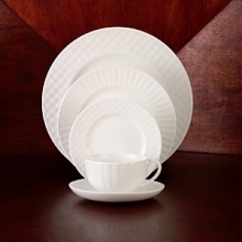 Simple shapes of crisp white are accented with precisely etched lines. Contrasting black matte jasper accessories with glazed interiors are also available. Bone china.