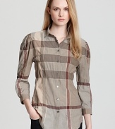 An elasticized waist and an A-line silhouette lend feminine spirit to the classic Burberry Brit check shirt. Style with dark denim and sleek flats for effortless polish.