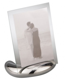 Keep memories fresh in the modern Elbow picture frame. A sculpted metal base turns back in an elegant curve, fitted with sheets of clear glass for displaying any photo, vertical or horizontal. Designed by Neil Cohen for Nambe. Keep memories fresh in the modern Elbow picture frame. A sculpted metal base turns back in an elegant curve, fitted with sheets of clear glass for displaying any photo, vertical or horizontal. Designed by Neil Cohen for Nambe.