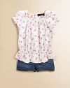 A sweet floral print covers this lovely smocked top with puff sleeves and an elasticized waist.Boatneck with ruffled trimShort puffed sleevesBack buttonsElastic waistCottonMachine washImported Please note: Number of buttons may vary depending on size ordered. 