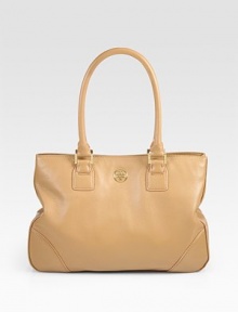 A clean design of luxe pebble-grain leather, with a signature goldtone emblem and side snaps for a cinched shape. Double top handles, 7½ dropMagnetic snap closureSide snapsProtective metal feetOne inner zip compartmentOne inside zip pocketTwo inside open pocketsCanvas lining13W X 9½H X 4DImported