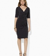 A charming print gives a chic graphic twist to a classic empire-waist dress in body-skimming matte jersey.