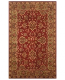 Drawing inspiration from the sandy ruins of ancient Petra and the traditional designs of India, this elegant, hand-tufted rug presents a rich decorative history set against a subtle red backdrop and accented with multiple gold and green tones.